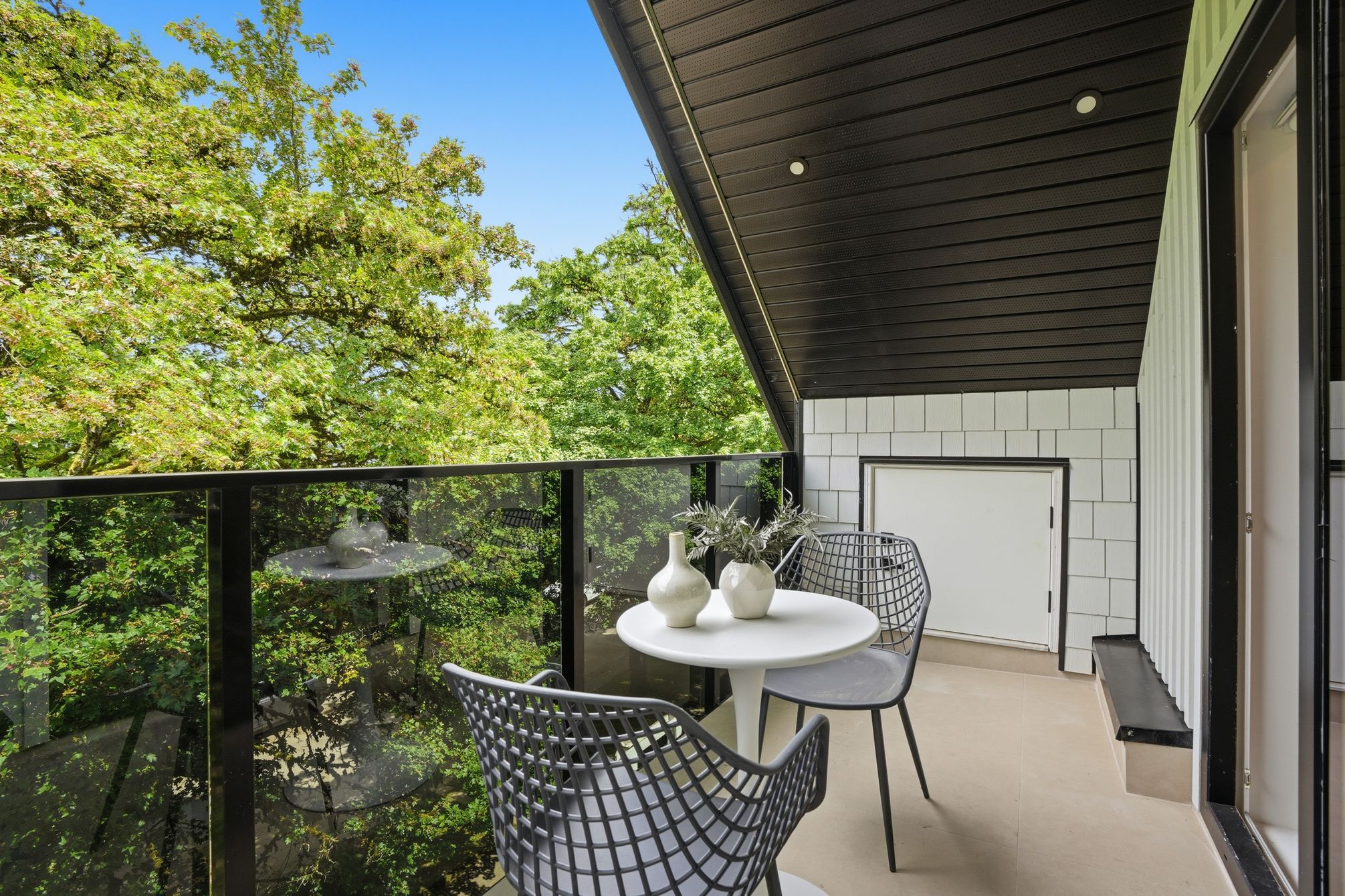Private covered balcony overlooking mature Vancouver trees